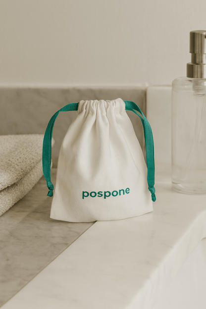 White drawstring bag with 'pospone' branding on a bathroom counter.
